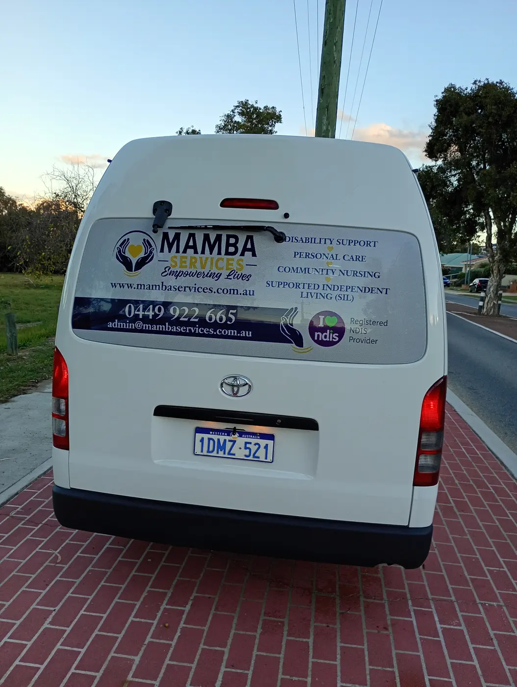 Rear of the Mamba Services wheelchair accessible van showing services offered and the registered NDIS provider badge